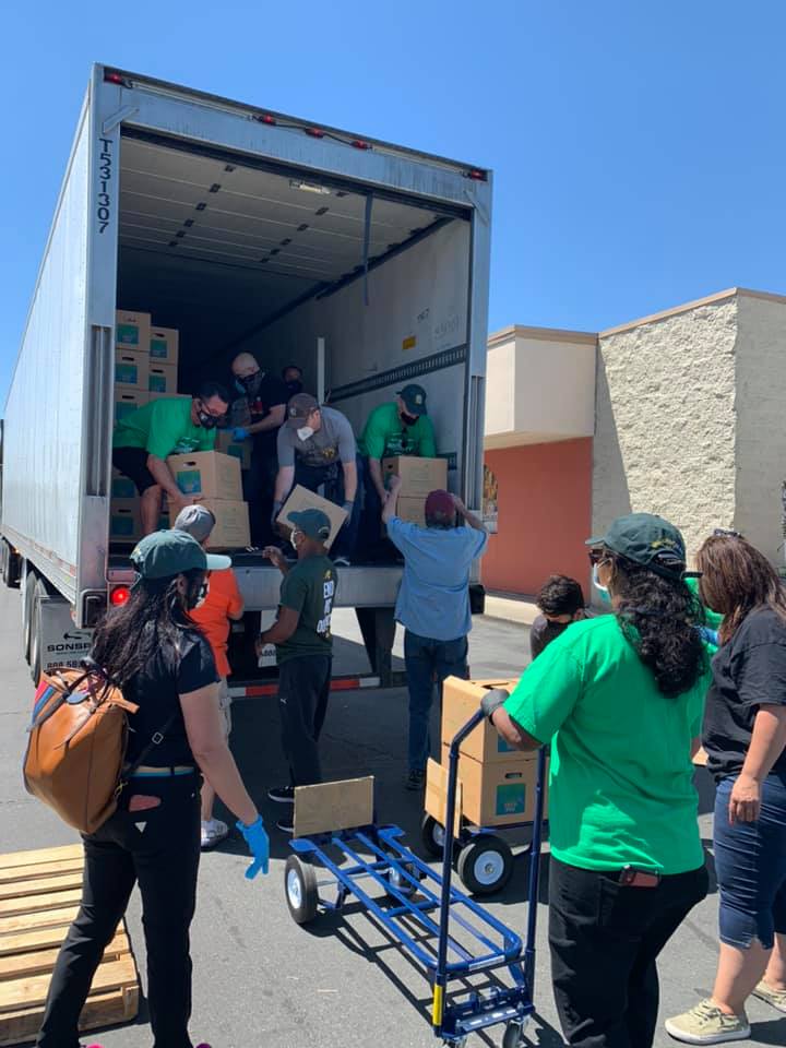 Volunteers unloading boxes of groceries for a distribution event.