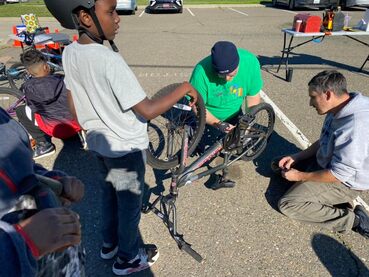 Volunteers teaching bicycle repair to kids.